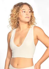 Top tipo soutien color beige claro, confeccionado en tejido rib acanalado elástico. Presenta escote en V profundo y breteles anchos fijos. Incluye copas desmontables y banda inferior ancha.