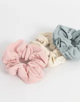 Set de tres scrunchies con textura acanalada en colores rosa, crema y celeste.