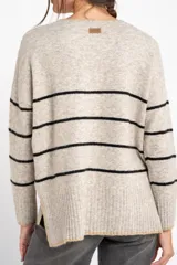 Sweater de punto con rayas en tonos naranja, morado y burdeos, de calce al cuerpo y mangas largas.