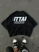 Remera color crema de corte recto y mangas cortas, con estampado en la espalda con el logo "ITTAI" en negro con líneas rojas, azules y blancas, y la leyenda "AN IBIZA PRODUCE. Ittai Stars Department Gallery - Ibiza Edition. If you're in Ibiza, 112 is not an option.".