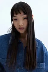 Vestido corto de denim azul, con cuello camisero, escote en V, manga corta y dos bolsillos de parche en el pecho.