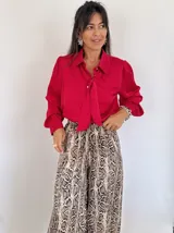 Camisa roja de mangas largas con puños abotonados y lazo en el cuello.