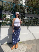 Top blanco con cuello halter, volados y espalda descubierta.