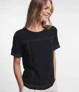 Blusa negra de viscosa con cuello redondo y mangas cortas. Presenta costuras contrastantes en blanco en el frente y las mangas.
