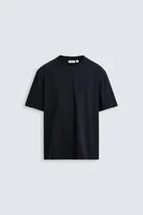 Camiseta negra de algodón de peso medio, corte recto, cuello redondo y mangas cortas.