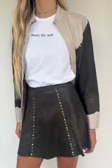 Minifalda negra con tachas doradas en el frente.