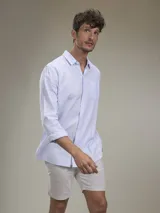 Camisa verde militar de manga larga, confeccionada en mezcla de lino y algodón. Tiene cuello clásico, cierre con botones y un bolsillo en el pecho.