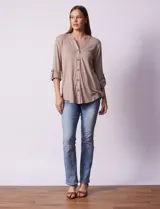Blusa blanca texturizada marca Ninety, con cuello a la base, escote en V, abertura central con botones, bolsillo delantero y mangas tres cuartos regulables con presilla y botón.