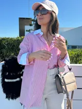Camisa larga a rayas verticales rojas y blancas, con cuello y puños blancos.