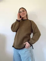 Sweater tejido a mano con lana color marrón. Tiene terminaciones en crochet con hilo de seda color negro. Silueta recta, cuello a la base y mangas ranglan baloon.