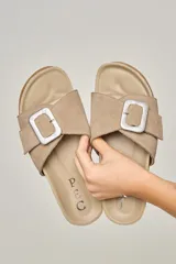 Sandalias color visón confeccionadas en cuero, con hebilla forrada de cuero, suela anatómica y acolchonada.