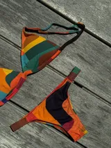 Conjunto de bikini turquesa con corpiño triangular de corte fijo, breteles regulables y almohadillas desmontables, y bombacha vedetina con frunce elástico en los costados.