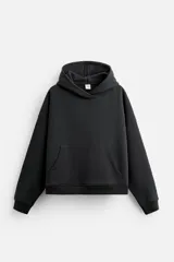 Sudadera negra corta con capucha, manga larga, bolsillo tipo canguro y terminaciones en rib.