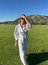 Camisa marrón con lunares blancos, corte clásico, cuello camisero, mangas 3/4 abullonadas y lazo ajustable en la cintura.