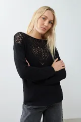 Sweater negro de tejido de punto con calado en la parte superior delantera y en los hombros.