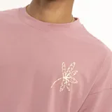 Remera manga corta color marrón con estampado de una flor dorada en el pecho.
