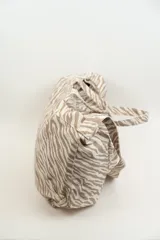 Bolso tipo tote bag con estampado de cebra en tonos beige y blanco. Tiene doble asa corta y correa larga para colgar del hombro.