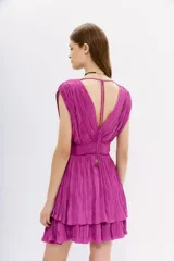 Vestido corto color fucsia con escote en V, sin mangas y falda con volados.