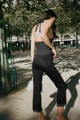 Pantalón negro de tiro alto con corte mini flare y volantes con estampado de lunares en el bajo.