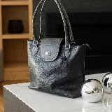 Cartera negra de cuero vacuno con bolsillo interno con cierre y cierres YKK metálicos.