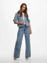 Chaqueta de jean celeste de corte clásico, con mangas largas con puños abotonados, cierre frontal con botones metálicos y bolsillos delanteros con solapa y botón.