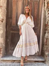 Vestido largo color blanco con bordados dorados, escote en V regulable y mangas cortas amplias.