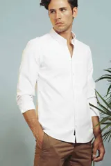 Camisa blanca de vestir, de corte clásico, con cuello abotonado y mangas largas.