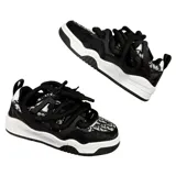 Zapatillas de skate negras con estampado de logos en blanco y gris, cordones gruesos negros, suela blanca y detalles en ecocuero.