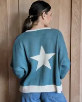 Buzo tostado de corte holgado con cuello redondo y manga larga. Presenta una estrella blanca estampada en la espalda y ribete marrón en cuello y ruedo.
