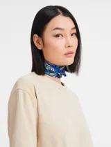Pañuelo de seda estampado, con diseño floral en tonos azules y verdes.