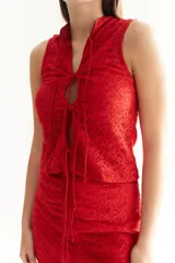 Chaleco rojo de encaje con lazos en el frente y cuello alto.