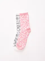 Pack de dos pares de medias de caña media: un par blanco con estampado de leopardo gris y un par rosa con lunares blancos.