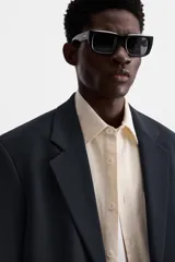 Blazer slim fit color azul marino confeccionado en tejido con viscosa. Cuello con solapas de muesca, manga larga con puño con detalle de botones, bolsillo de vivo en pecho y de solapa en cadera, bolsillo interior, bajo con aberturas en espalda y cierre frontal con botones.