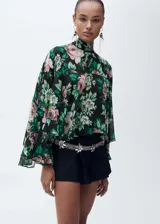 Blusa de gasa con estampado floral, cuello alto, manga larga con volantes y cierre de lazo en la parte posterior.