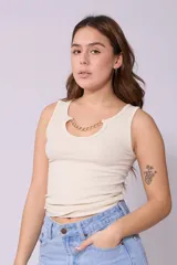 Musculosa color crema de corte ajustado, con cuello redondo y detalle de cadena dorada en el escote.