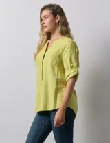 Blusa color verde claro de lino marca Cupio, con cuello a la base, escote en V y abertura con botones. Tiene un bolsillo en la parte delantera y mangas 3/4 regulables con presilla y botón.
