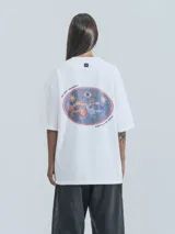 Remera blanca de corte holgado con estampado de dragones en círculo con texto 'No Art Uruguay' y 'Castillo de Piria'.