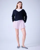 Sweater negro de cashmere cepillada con cuello en V, corte oversize, mangas largas y terminaciones acanaladas.