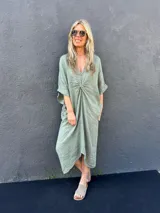 Vestido midi verde oliva de lino, con escote en V y detalle de nudo en la parte delantera.