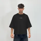 Remera negra de corte boxy fit con estampado blanco en la espalda con el logo "venefa" y la frase "where fear flips into style. street-born, future-bound.".