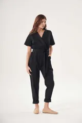Mono negro de tela liviana con cuello camisero, mangas cortas y corte cruzado con cinturón.