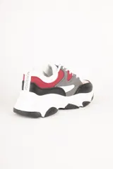 Zapatillas blancas con recortes en diferentes tonos de gris, cordones y plataforma irregular de 5cm.