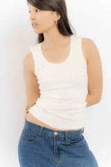 Musculosa blanca de algodón con breteles finos y corte ajustado.