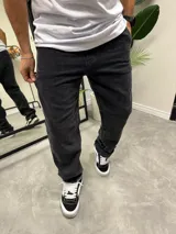 Pantalón de jean negro con efecto gastado, corte amplio y tiro medio.