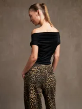 Top negro con escote off-shoulder y corte irregular en el ruedo.