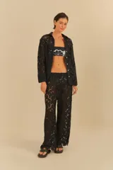 Pantalón negro de corte amplio y fluido, con detalle de encaje floral.