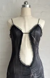 Minivestido gris con estampado difuminado, escote halter con detalle de encaje negro, abertura en el abdomen y falda con volados.