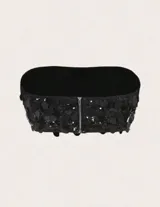Conjunto de dos piezas, top tipo bandeau y mini falda, ambos completamente cubiertos de lentejuelas negras.