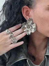 Aros grandes plateados con forma de flor.
