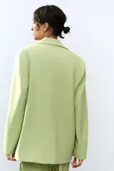 Blazer oversize color verde lima, con cuello solapa y mangas largas con hombreras. Tiene bolsillos delanteros y en el pecho, forro interior y cierre frontal multiposición.